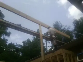 Carpenter setting a ridge beam over a new addition frame — Ice Dam Removal by Roofing Brothers in Willow Grove