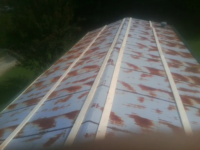 Rusted metal roof panels with new wood purlins before replacement — Storm Damage Roof Repair in Willow Grove by Roofing Brothers